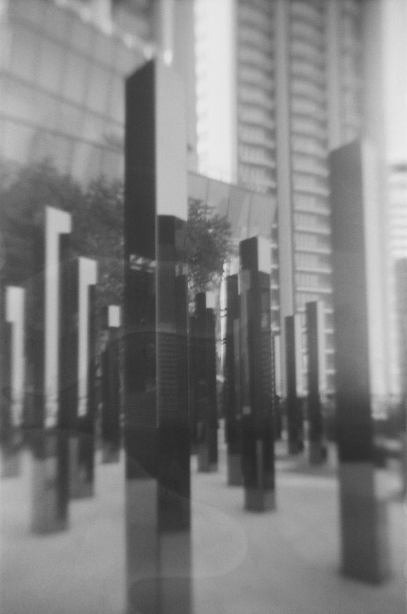a collection of black pillars with mirrored surfaces