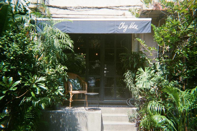 a cafe storefront framed by foliage